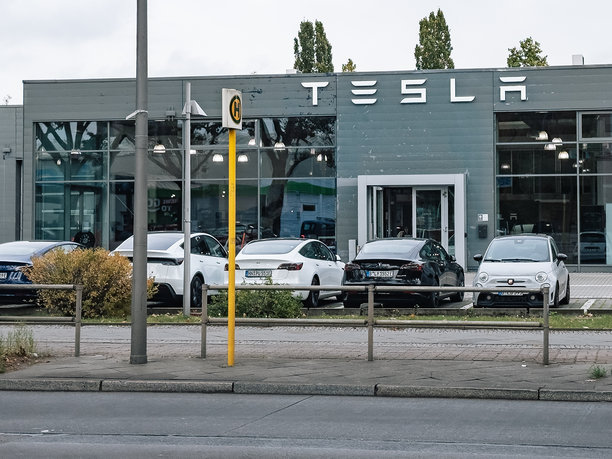 德国特斯拉经销商展厅入口正面特写，入口外停放着电动汽车图片下载