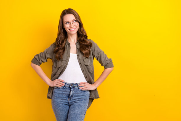 照片：一位长发棕色头发、戴眼镜、穿着衬衫的聪明女学生，眼神空洞地望向别处，背景为黄色图片下载