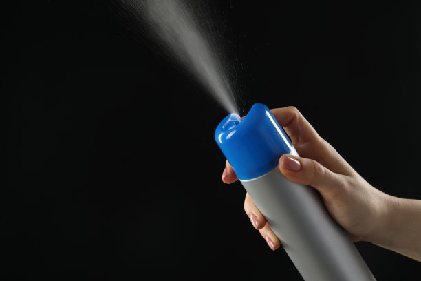 特写镜头，一名女子在黑色背景前喷洒空气清新剂，留有文字空间。图片下载