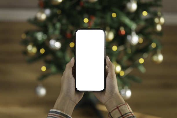 手持智能手机屏幕模型，背景为节日圣诞灯饰，强调数字节日营销、移动应用推广和季节性在线互动图片下载
