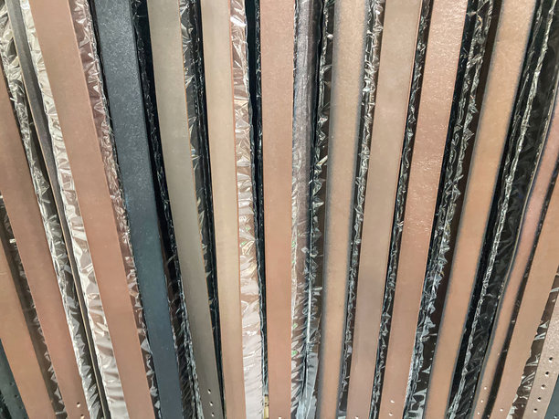 抽象图案中重叠的、红橙色的金属碎片集合，大小和方向各不相同。室内环境，有柔和的阴影，无文字或品牌标志。静物构图，聚焦于图片下载