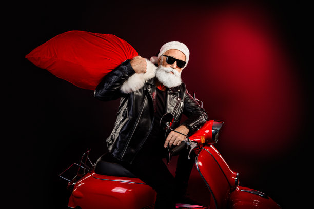 酷炫的摇滚风圣诞老人，身穿皮夹克、戴着太阳镜，骑着红色摩托车，载着大包，为节日季营销造势图片下载