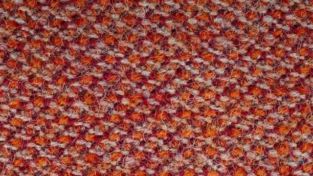 宏观的织物纹理照片，可用作背景。织物由红色、橙色和白色线混合而成，材质为合成纤维和羊毛的混合物。抽象图案。图片下载