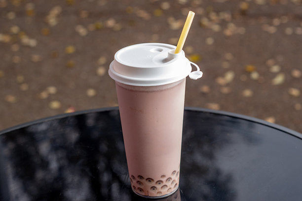 一个高玻璃杯里的珍珠奶茶，配有吸管，方便外带图片下载