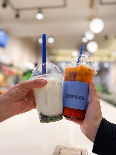 朋友们在咖啡馆举杯畅饮冰饮，包括珍珠奶茶和冰咖啡，共同庆祝友谊。图片下载