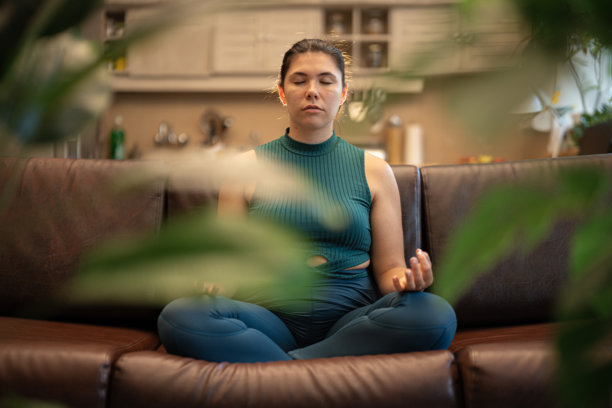 女性健康。宁静的亚洲女性在家中绿植环绕的环境中冥想图片下载
