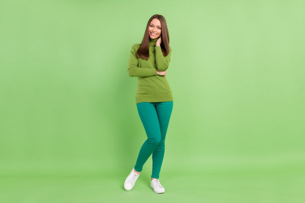 快乐的年轻女子，面带笑容，手部姿势，心情愉悦，在绿色背景前，全尺寸照片图片下载