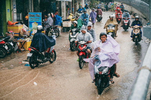 越南民众骑摩托车从芽庄市洪水区撤离，此前该地区遭遇洪水和强降雨。越南芽庄 - 2025年11月21日图片下载