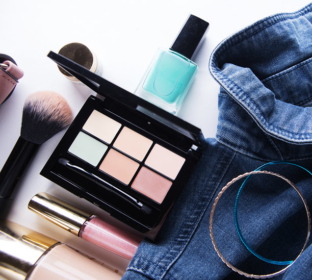 俯视女性牛仔衬衫、遮瑕盘、唇彩、指甲油、手镯、散粉刷在白色背景上的照片。图片下载