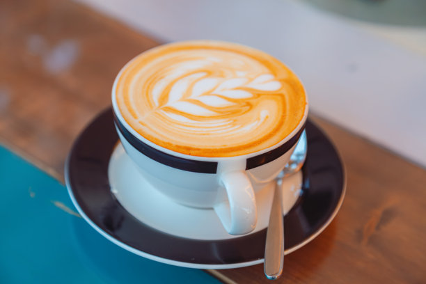 在舒适的咖啡馆里，奶油般绵密的手工拉花拿铁图片下载