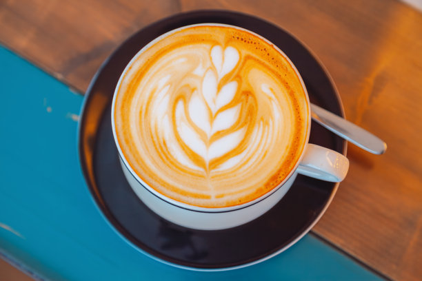 舒适咖啡馆里的奶油手工拿铁拉花艺术图片下载