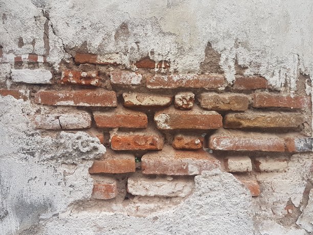 剥落的灰泥下露出陈旧、饱经风霜的红砖墙；破损的白色灰泥墙展示着复古砖块的图案；破败墙壁的纹理背景，露出历史建筑结构。图片下载