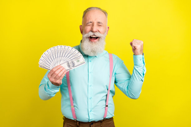 照片：一位戴着蓝衬衫、双手握拳、面露惊叹之色的老年男子，背景为黄色图片下载