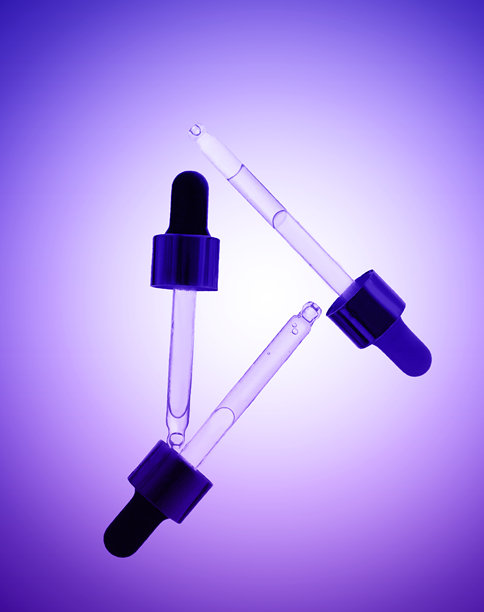 浅紫色背景下的三支含面部精华的玻璃滴管。液体凝胶或精油的正面特写，用于抗衰老化妆品广告的横幅。图片下载