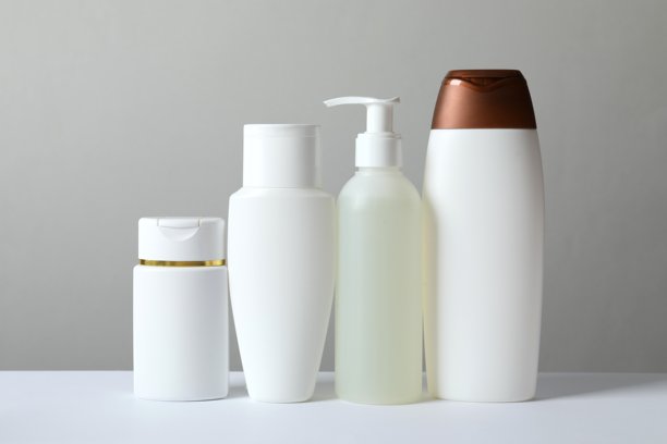 一套化妆品瓶，浴室里的乳霜罐。个人卫生的洗漱用品。塑料容器，液体皂液器。各种美容护理产品在粉色浴室的桌子上。洗发水，发膜。图片下载