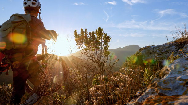 日落时分，山地自行车骑行者在山上搬运电动自行车图片下载