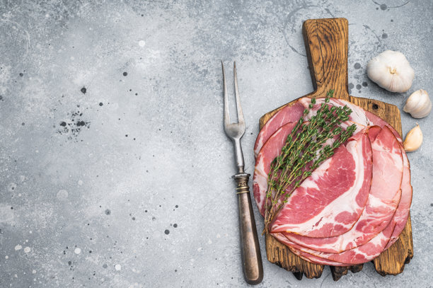 意大利 Coppa Capicola 猪肉片配百里香，放在乡村木板上，背景为灰色石头，非常适合美食图片素材。图片下载