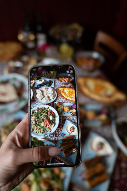 用智能手机在节日餐桌上拍摄美食照片图片下载