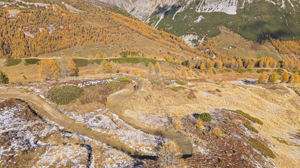 航拍，山地自行车骑手在蜿蜒的山路上骑行，意大利利维尼奥图片下载