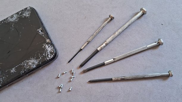 破损的智能手机屏幕和准备维修的工具图片下载