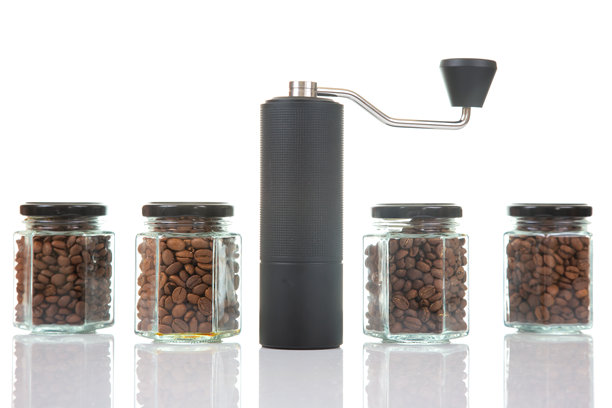 白色背景上展示着咖啡研磨机和装有烘焙咖啡豆的玻璃罐图片下载