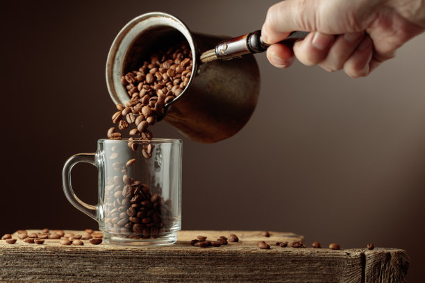 咖啡豆被倒入透明玻璃杯中图片下载