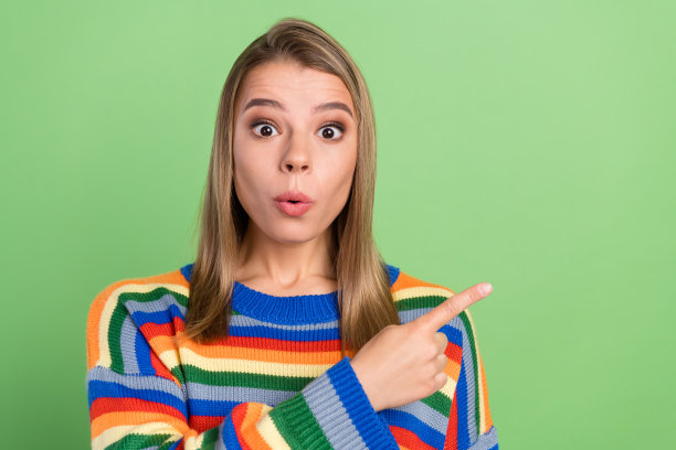 女孩照片肖像，手指惊讶地指向空白处，背景为粉绿色图片下载