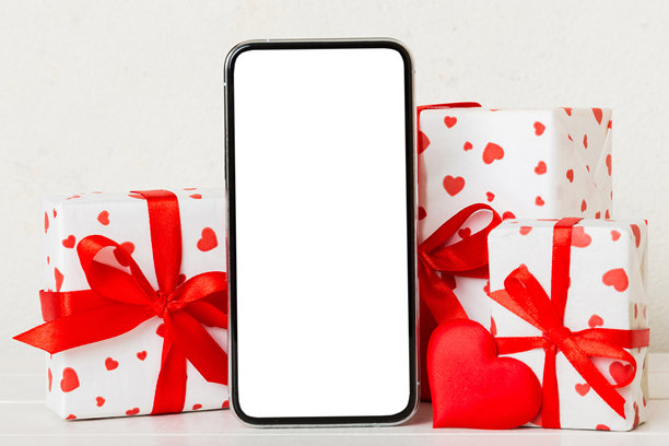 彩色背景上的手机，带有空白屏幕、爱心、日历和礼品盒，情人节概念，透视平铺视图图片下载