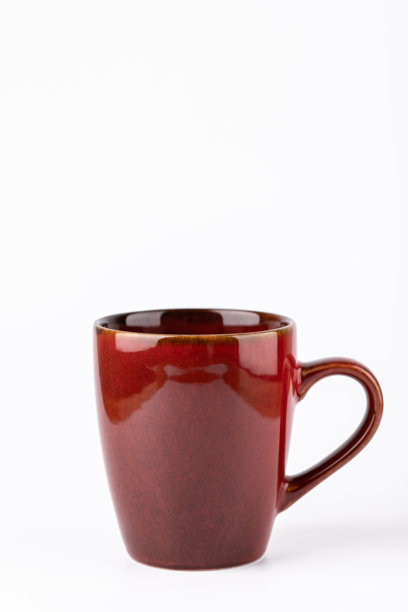 深红色陶瓷马克杯居中于白色背景上，竖构图，留有复制空间。温暖的极简主义照片，适合社论设计或广告。早晨例行公事和舒适生活方式的概念。图片下载