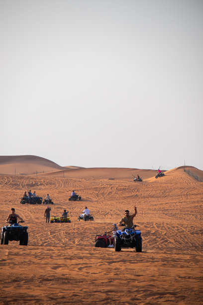 一群四轮摩托车骑手在沙漠沙丘上摆姿势图片下载