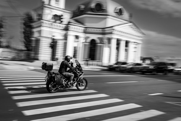 摩托车手在教堂前的斑马线上骑行图片下载