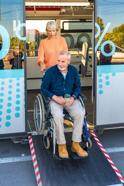 女人搀扶坐轮椅的老人上公交车图片下载