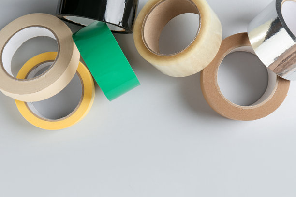 白色背景上卷起来的各种胶带，俯视角度。留有文字空间。图片下载