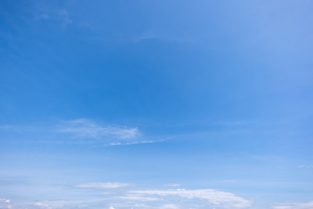 蓝天白云全景图，带有细小云朵的蓝天背景。蓝天中的白色蓬松云朵。迷人的天空和云朵的股票照片。图片下载