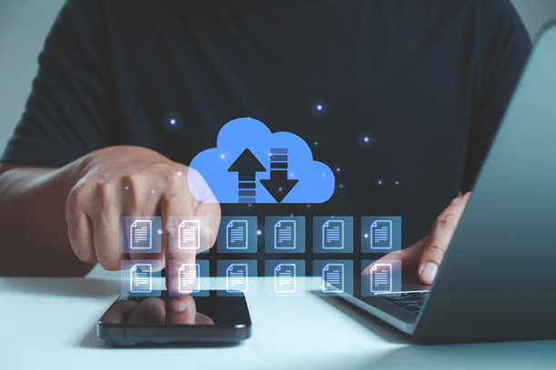 一个人使用智能手机和笔记本电脑，配有安全云存储图标和文件传输概念。人工智能技术平台提供数字数据保护和在线备份。图片下载