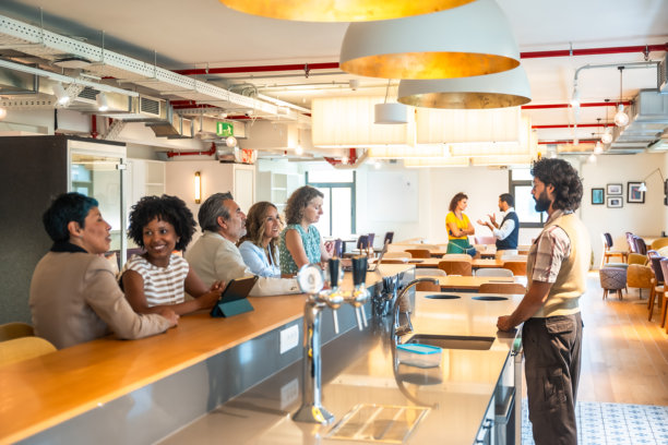 不同背景的同事在现代联合办公空间的吧台处社交图片下载