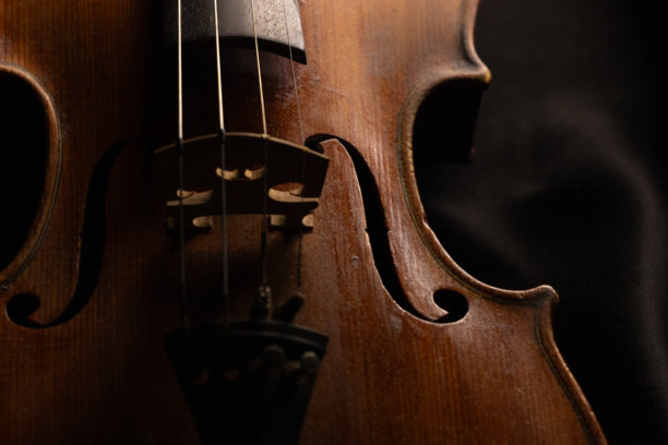 特写镜头，一把旧木制小提琴，背景为黑色，留有文字空间图片下载