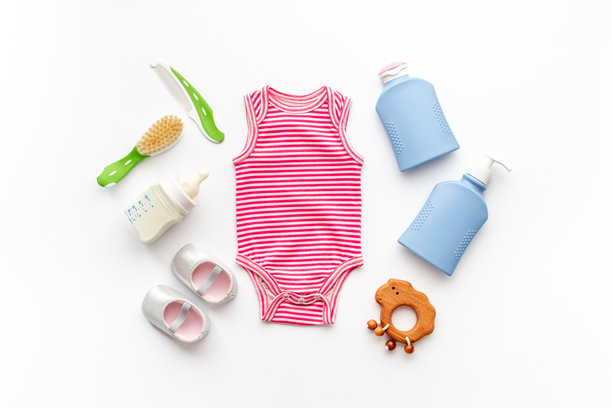 婴儿卫生化妆品套装 - 洗发水、肥皂和梳子。环保配件 - 婴儿连体衣、木制玩具和奶瓶，白背景，俯视图片下载