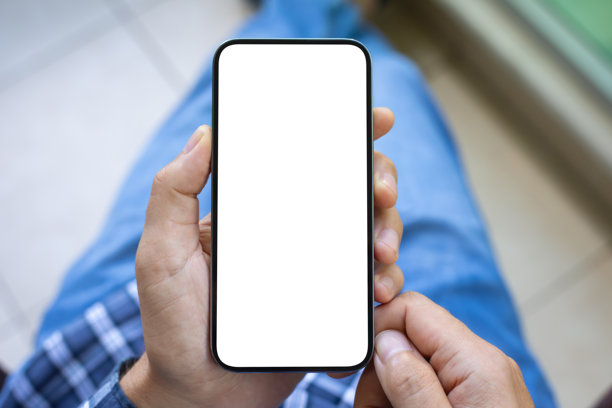 男士手持手机，手机屏幕在牛仔裤背景上独立显示图片下载