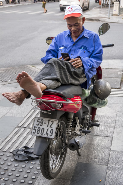 司机在西贡街头骑摩托车休息图片下载