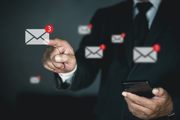 商务人士在智能手机上收发电子邮件，有商务邮件在线通知提醒。商务人士在虚拟屏幕上触摸电子邮件。图片下载