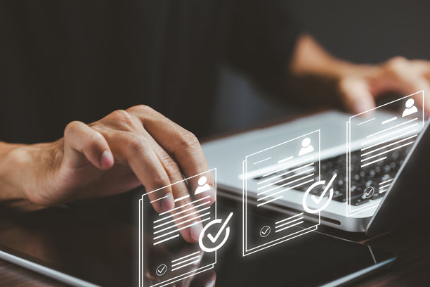 一个人正在使用笔记本电脑，屏幕上漂浮着数字简历图标，代表在线求职、数字档案、人力资源技术、招聘流程和现代招聘系统。图片下载