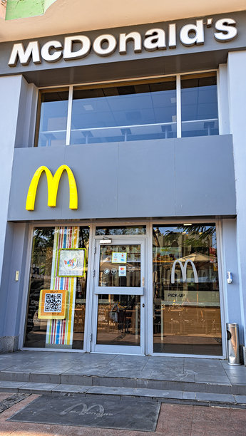 埃及赫尔格达麦当劳餐厅入口，拥有标志性的金色拱门和充满活力的外观设计，并留有品牌宣传的复制空间图片下载