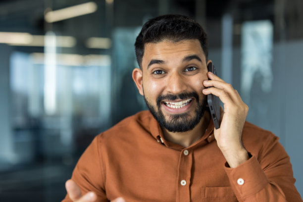快乐的男人在现代办公室里打电话图片下载