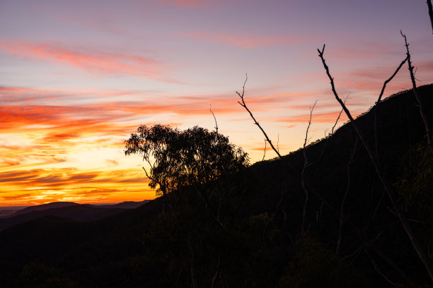 从怀特格姆观景台的高处望去，绚烂的日落余晖洒在瓦伦邦格尔国家公园的山地地貌上图片下载