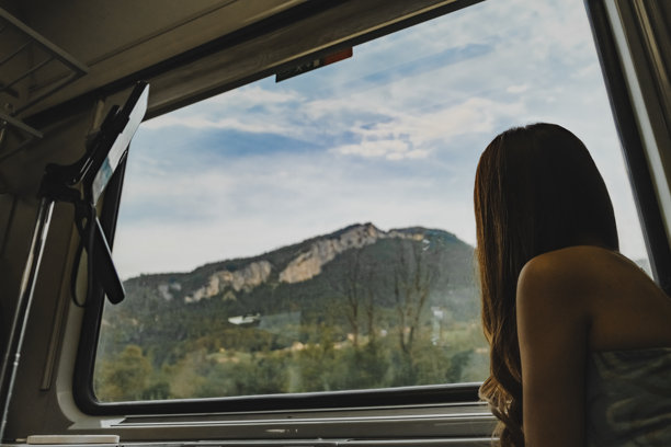 乘客坐在火车座位上欣赏窗外风景的素材照片图片下载