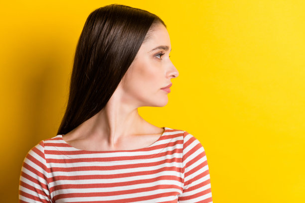 身穿红色毛衣的严肃千禧风女士的个人资料照片，孤立在充满活力的黄色背景上，目光望向空白处图片下载