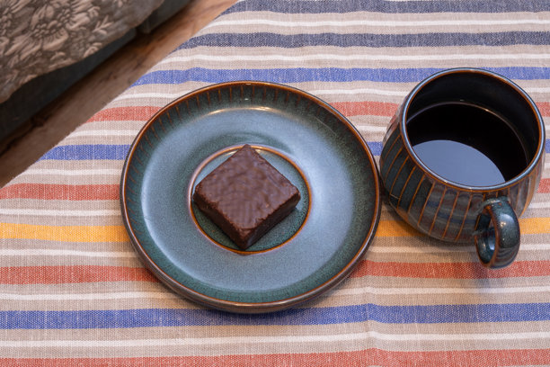 巧克力布朗尼配黑咖啡在陶瓷盘上。甜点、咖啡休息、居家舒适。真实照片图片下载