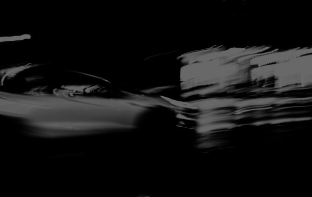 模糊动态中的白色汽车。使用单色传感器拍摄的照片。图片下载