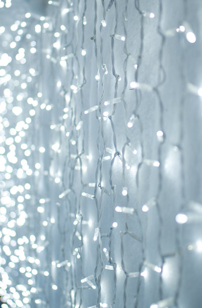 白色背景上的发光圣诞彩灯。竖版照片。图片下载